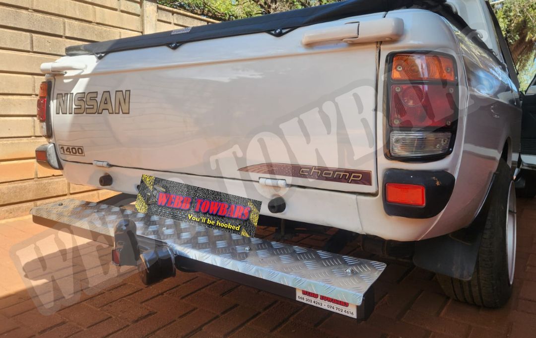 Webb Towbars - Nissan 1400 - Straight Pipe with Step Towbar professionally manufactured and expertly fitted by Webb Towbars in Gauteng, South Africa. Heavy-duty straight pipe towbar with integrated rear step, precision-engineered specifically for the Nissan 1400 bakkie to provide exceptional towing performance and everyday practicality. Designed for secure towing of trailers, utility trailers, camping equipment and work-related loads, this durable towbar features a corrosion-resistant finish, vehicle-specific fitment and robust construction for long-lasting reliability. Expertly manufactured and installed by Webb Towbars, delivering strength, safety and a professional finish trusted by Nissan 1400 owners throughout Gauteng and South Africa.